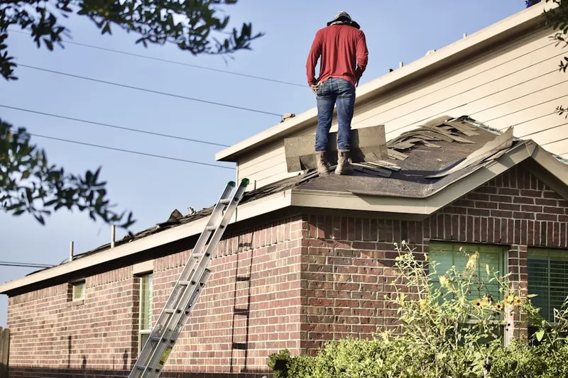 Professional roofer working on a residential roof in Planeview